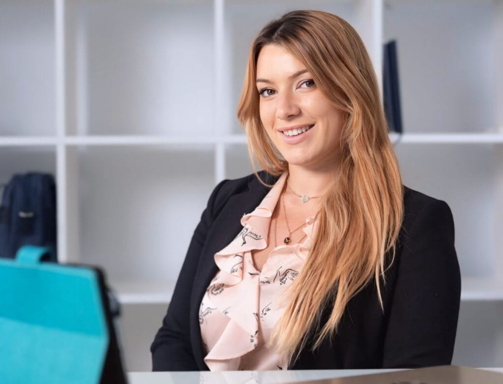 Aroa, asesora financiera, sentada en su despacho frente a una mesa con un iPad, brindando asesoramiento financiero