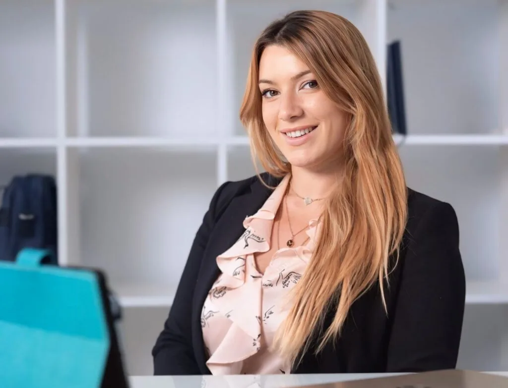 Aroa, asesora financiera, sentada en su despacho frente a una mesa con un iPad, brindando asesoramiento financiero